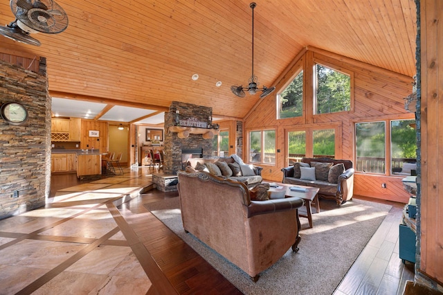 living room with ceiling fan, beam ceiling, a fireplace, high vaulted ceiling, and wooden ceiling