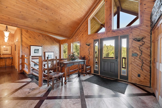 entryway featuring wooden ceiling, high vaulted ceiling, and wood walls