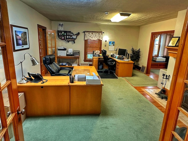 office space with a textured ceiling and carpet floors