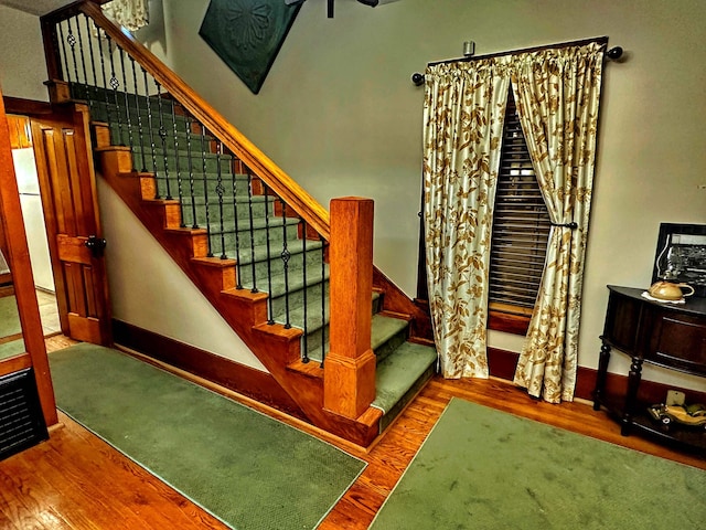 stairs with dark hardwood / wood-style flooring