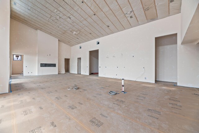 unfurnished living room with high vaulted ceiling