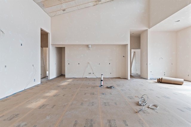 unfurnished living room with a towering ceiling