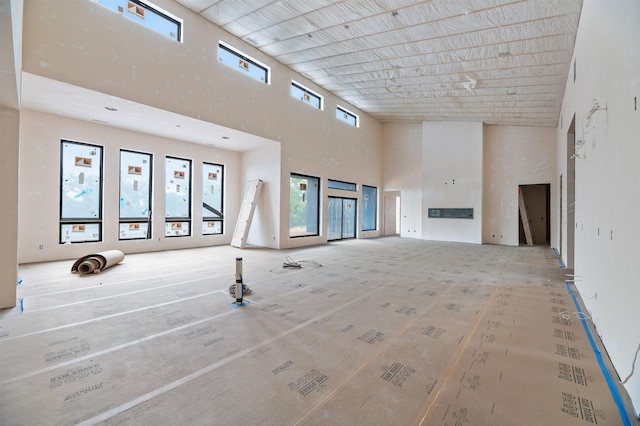 unfurnished living room with a towering ceiling