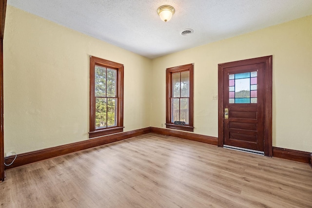 entryway with a textured ceiling and light hardwood / wood-style floors