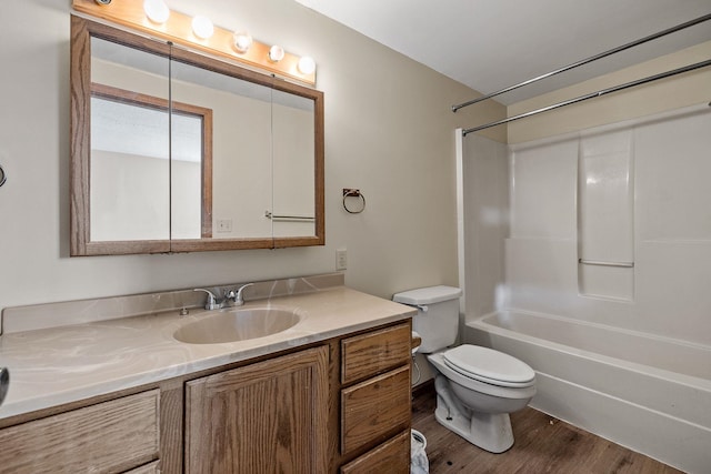 full bathroom with vanity, toilet, wood-type flooring, and washtub / shower combination