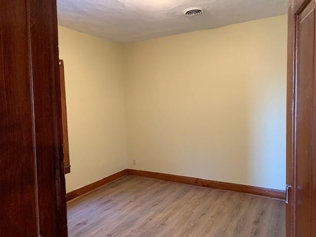 empty room with light hardwood / wood-style flooring