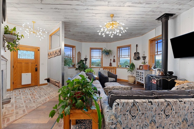 living room featuring light parquet floors, a wood stove, and a chandelier