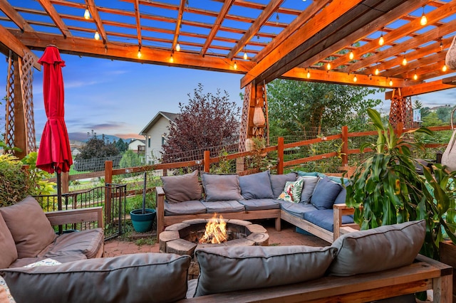 patio terrace at dusk featuring a pergola and an outdoor living space with a fire pit