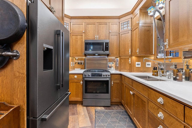 kitchen with appliances with stainless steel finishes, sink, and wood-type flooring