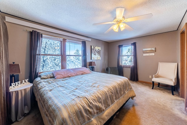 carpeted bedroom with ceiling fan and a textured ceiling