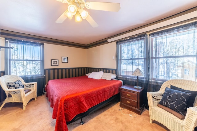 carpeted bedroom featuring crown molding and ceiling fan