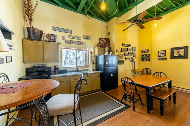 kitchen with black appliances, ceiling fan, light wood-type flooring, and light brown cabinets