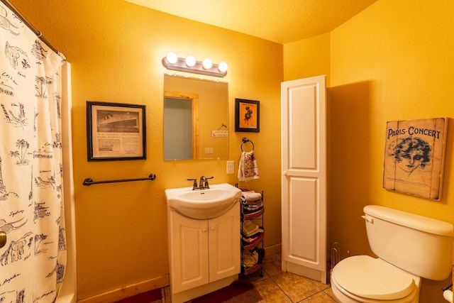 bathroom with a textured ceiling, vanity, toilet, and tile floors