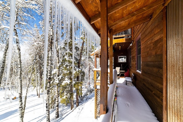 view of snow covered back of property