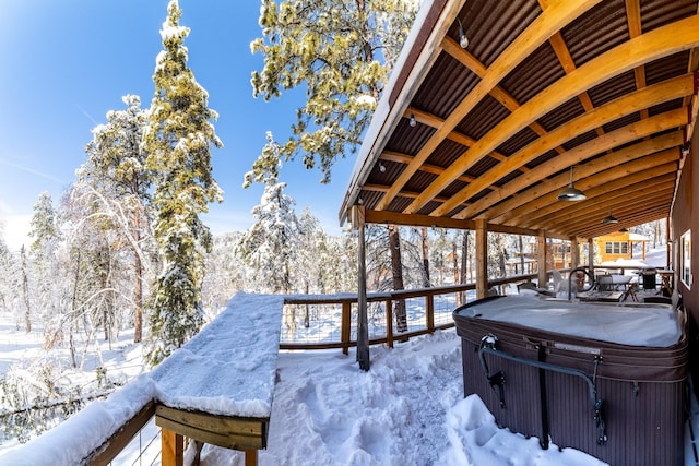 snow covered deck with a hot tub