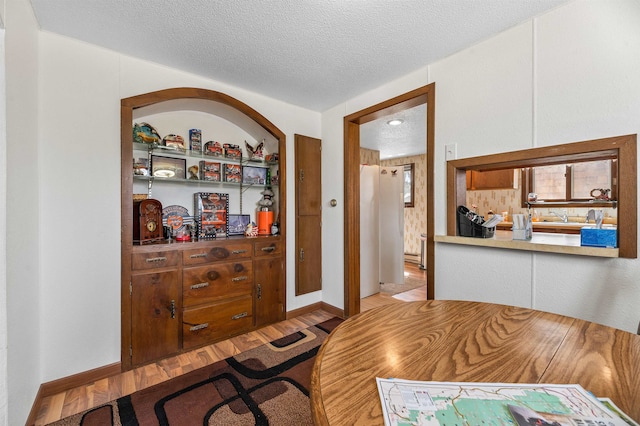 office space with sink, light hardwood / wood-style flooring, and a textured ceiling