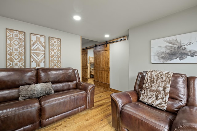 living room featuring a barn door and light hardwood / wood-style flooring