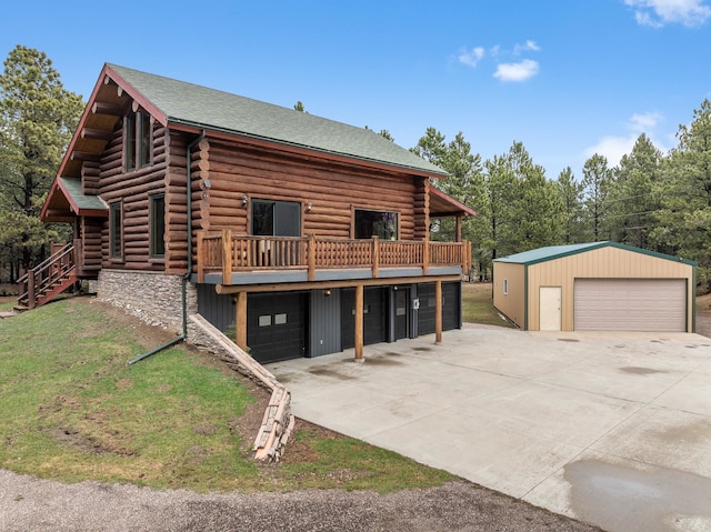 log home featuring a deck, a garage, and an outdoor structure