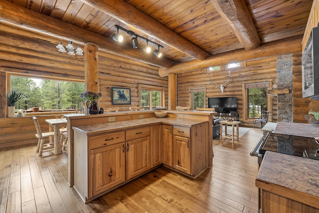 kitchen featuring rustic walls, beam ceiling, wood ceiling, and light hardwood / wood-style flooring