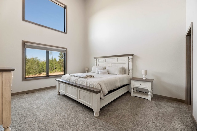 carpeted bedroom featuring a towering ceiling