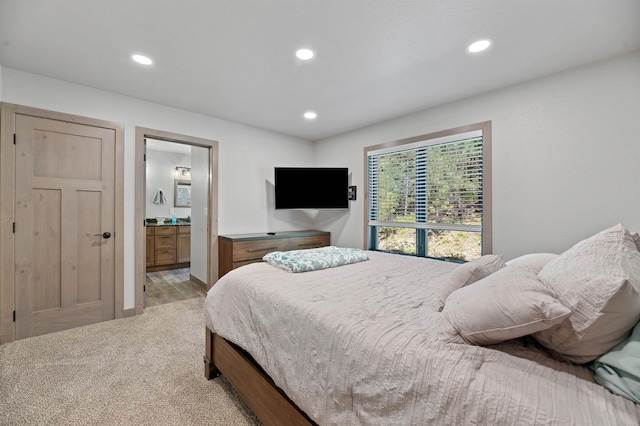 carpeted bedroom featuring ensuite bath