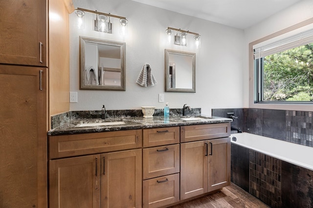 bathroom featuring hardwood / wood-style floors, dual bowl vanity, and tiled bath