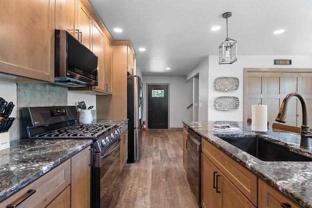 kitchen featuring decorative light fixtures, dark hardwood / wood-style flooring, black appliances, sink, and tasteful backsplash