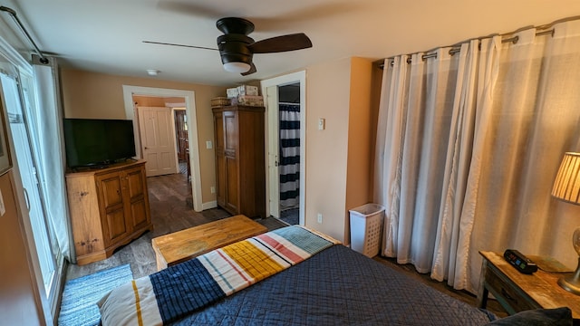 bedroom featuring dark hardwood / wood-style floors, ensuite bath, and ceiling fan