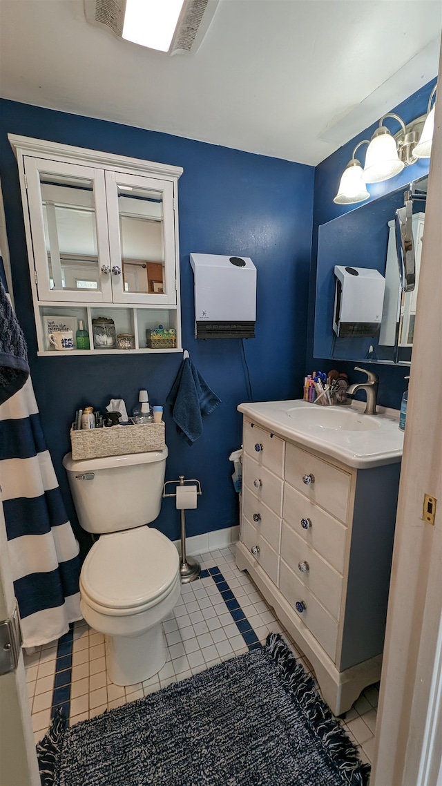 bathroom with tile flooring, vanity, and toilet