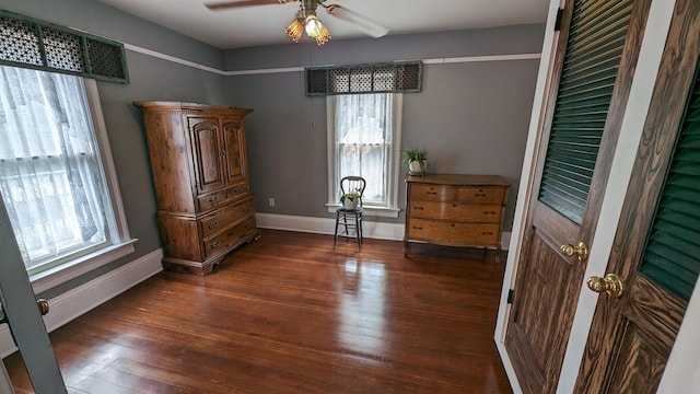 unfurnished bedroom with ceiling fan and dark wood-type flooring