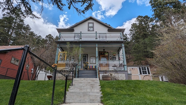 view of front of house with a front yard and a balcony