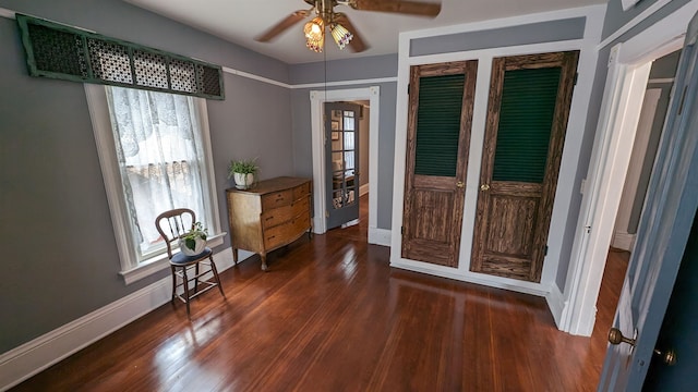 interior space with dark wood-type flooring, ceiling fan, and multiple closets