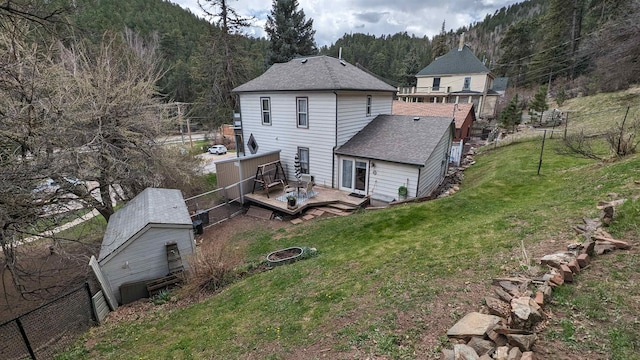 rear view of property featuring a yard and a wooden deck