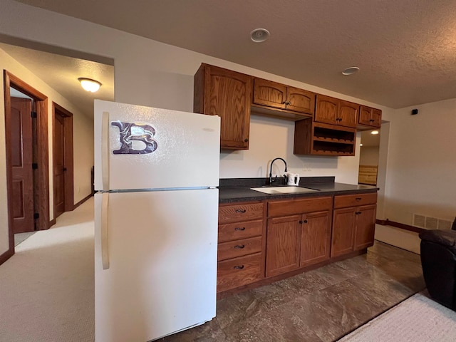 kitchen featuring carpet, white fridge, and sink