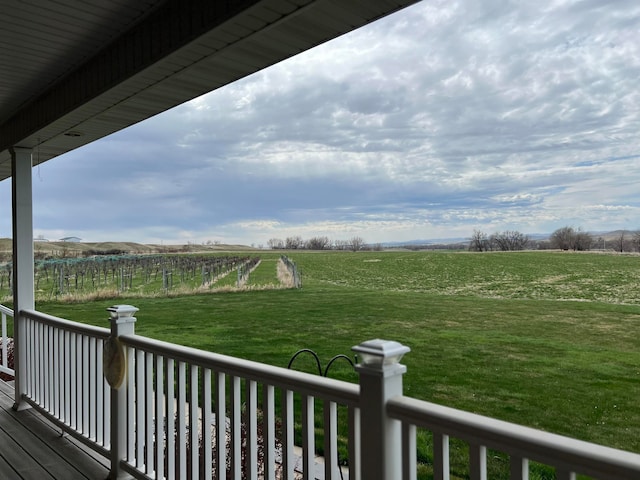 wooden deck featuring a rural view and a yard