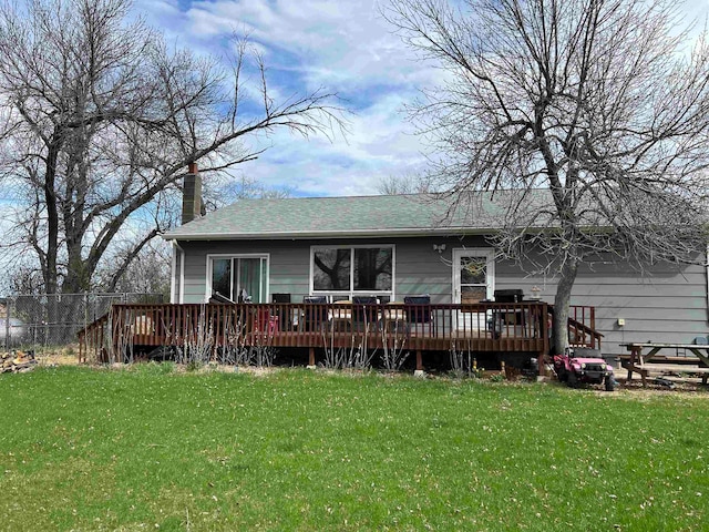 back of house with a deck and a yard