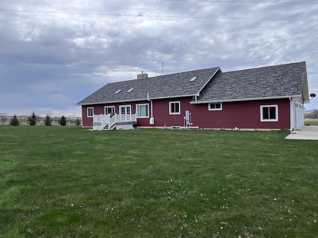 rear view of house featuring a yard