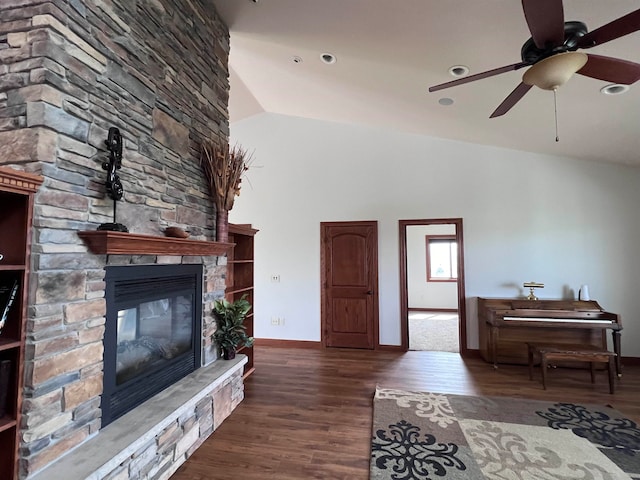 living room featuring vaulted ceiling, ceiling fan, a fireplace, and dark hardwood / wood-style floors