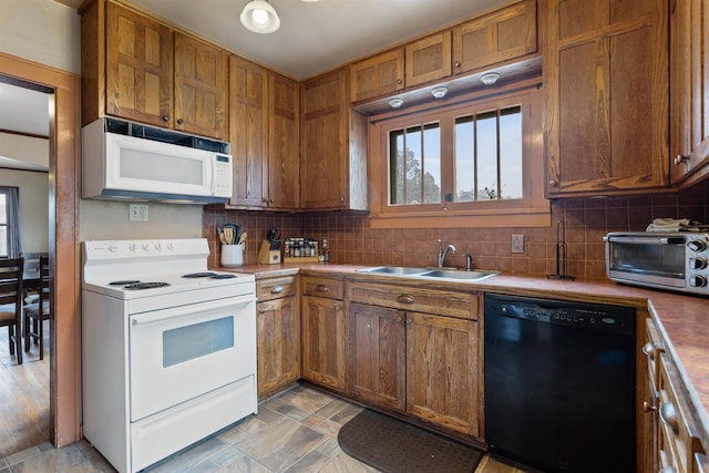 kitchen featuring backsplash, white appliances, light hardwood / wood-style floors, and sink