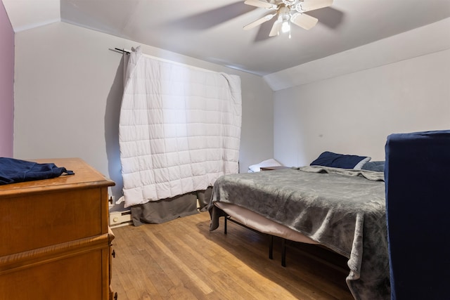 bedroom featuring wood-type flooring, ceiling fan, and vaulted ceiling