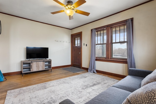 living room with hardwood / wood-style flooring, ornamental molding, and ceiling fan