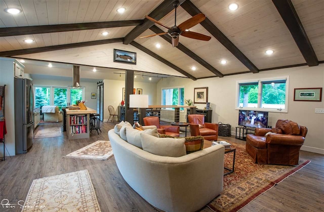 living room with ceiling fan, dark hardwood / wood-style floors, lofted ceiling with beams, and plenty of natural light