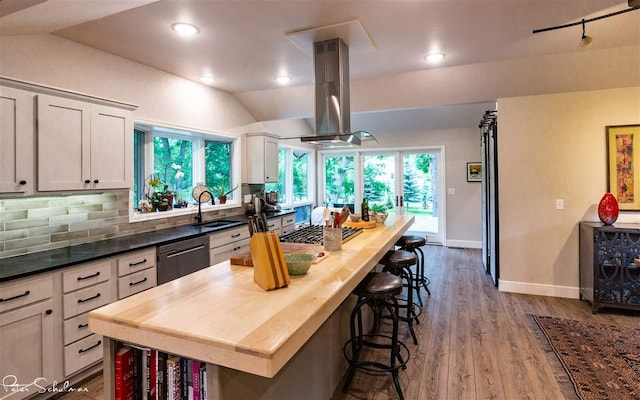 kitchen featuring vaulted ceiling, dishwasher, a center island, and light hardwood / wood-style flooring