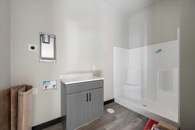 full bathroom with baseboards, walk in shower, wood finished floors, and vanity