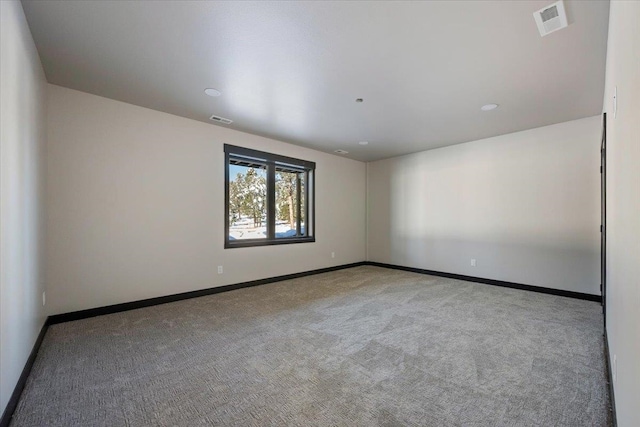 empty room featuring carpet, visible vents, and baseboards