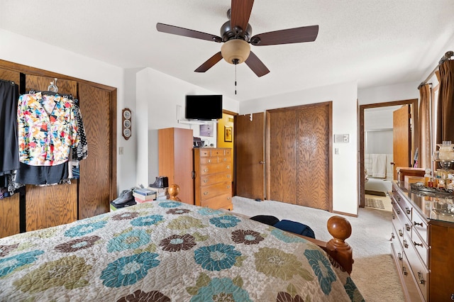 carpeted bedroom with ceiling fan and a textured ceiling