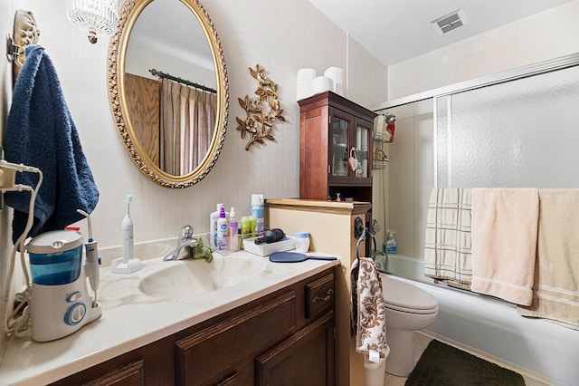 full bathroom with toilet, bath / shower combo with glass door, and vanity