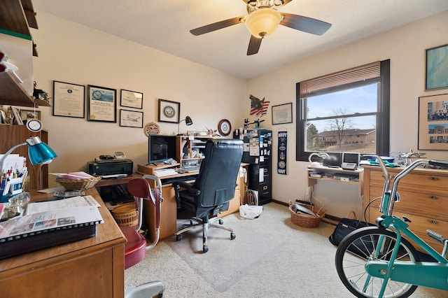 carpeted office featuring ceiling fan