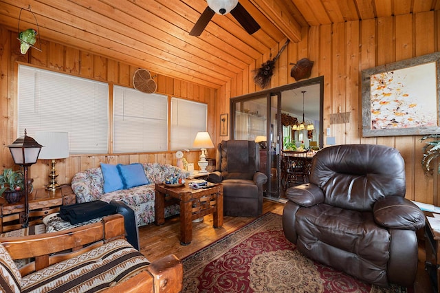 living room with wood walls, ceiling fan, vaulted ceiling with beams, wood-type flooring, and wood ceiling