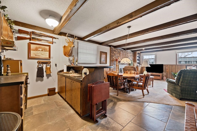 kitchen with tile flooring, a textured ceiling, beam ceiling, and decorative light fixtures